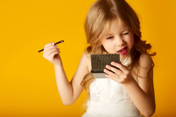 Fille avec miroir rougissant sur fond jaune — Photo