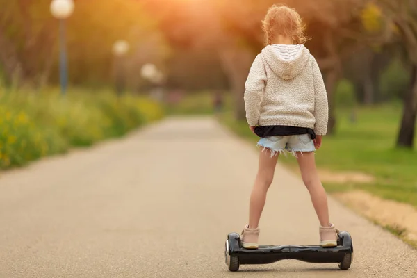 Chica montando en el hoverboard en el parque — Foto de Stock