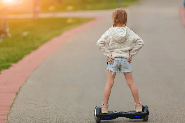 Chica montando en el hoverboard en el parque — Foto de Stock