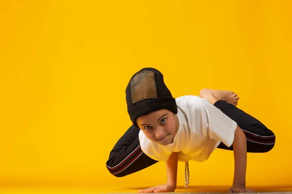 Pequeña bailarina de hip hop feliz - niño bailando aislado sobre fondo amarillo —  Fotos de Stock