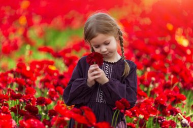 kırmızı çiçekli kız buttercups, parlak güneş, güzel yaz manzara bir alanda poz