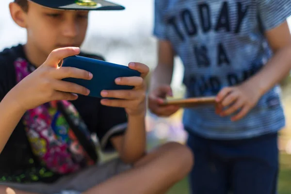 Preschool boys playing on smartphone. Sunny day. people, technology, leisure concept — Stok fotoğraf