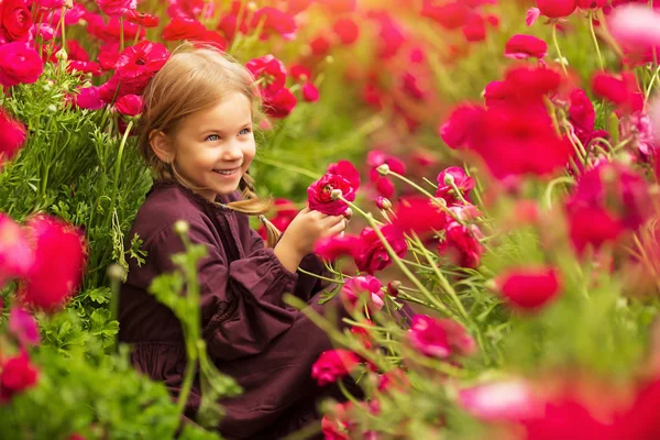 Chica alegre entre flores brillantes de primavera de buñuelos —  Fotos de Stock