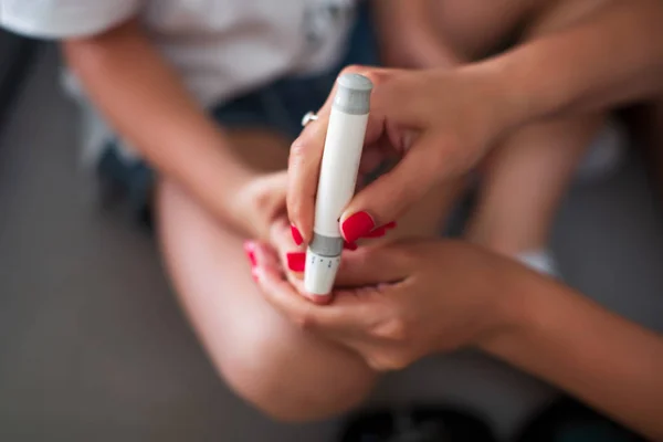 Женщина с помощью Ланселет на пальце, диабет тест проверки уровня сахара в крови — стоковое фото