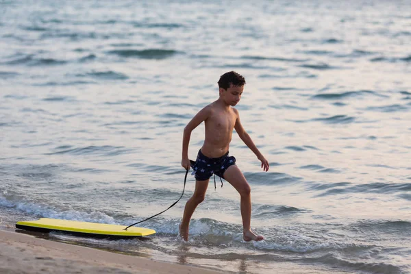 Poco surfista ejecutar con bodyboard a mar para montar en olas — Foto de Stock