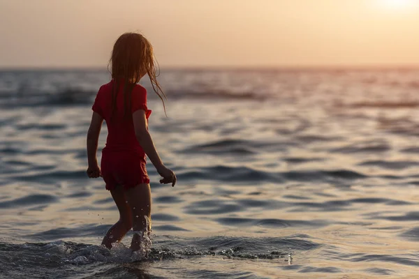 Niña solitaria en la playa del mar al amanecer de la mañana —  Fotos de Stock