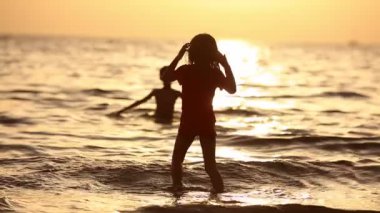 Mutlu çocuk sahilde günbatımı anda oynamak. Mutlu dostu aile kavramı