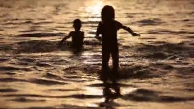 Dışarıda suda eğlenen çocuklar. Mutlu Çocuklar neşeli küçük erkek ve kız Sea Water oynuyor