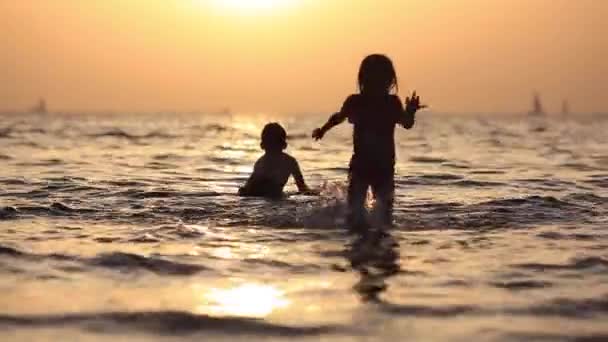 Kinder vergnügen sich im Wasser im Freien. glückliche Kinder freudige kleine Jungen und Mädchen, die im Meerwasser spielen — Stockvideo