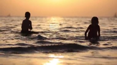 Mutlu Çocuklar neşeli küçük erkek ve kız deniz Suyu oynarken. Yaz tatilleri. Yaz eğlencesi