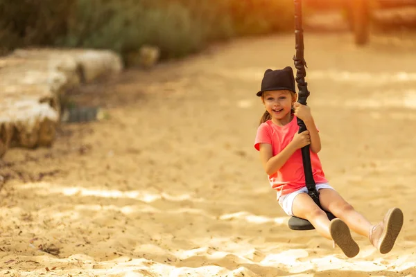 Sonriente chica cabalgando un bungee en un parque en el patio de recreo — Foto de Stock