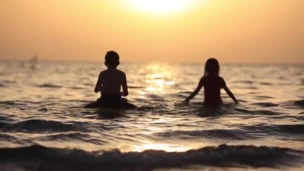 Garotinha e garotinho se divertindo na praia. Movimento lento — Vídeo de Stock