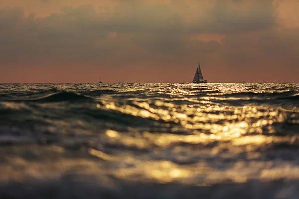 Dramáticas nubes sobre mar tormentoso y yate solitario —  Fotos de Stock