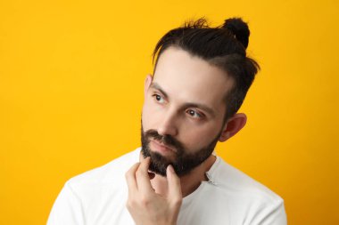 dalgın sakallı adam sarı bir arka plan üzerinde