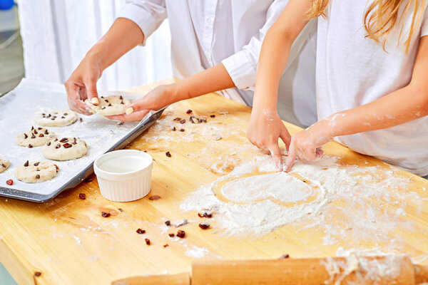 Mother and the daughter draw heart on a table. The data represents love and family.