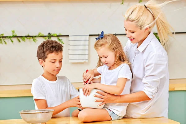 Familia feliz preparando pastelería en la cocina juntos — Foto de Stock