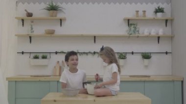 Mutlu aile komik çocuklar mutfakta un ile oynarken hamur hazırlama