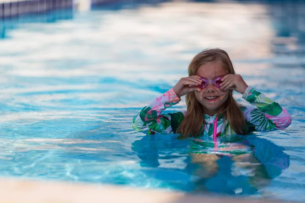 Bébé fille souriante portant des lunettes de bain dans la piscine — Photo