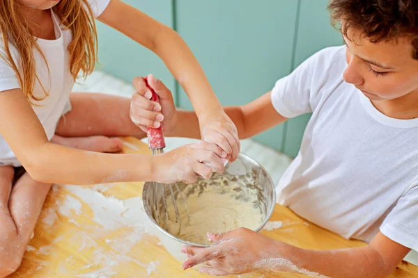 Hermano y hermana están batiendo huevos en la cocina — Foto de Stock