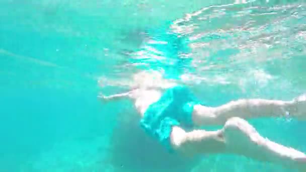 Tiro subaquático de um menino bonito snorkeling com uma máscara e tubo — Vídeo de Stock