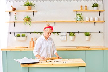 Genç bir kadın evde Noel kurabiyesi pişiriyor.