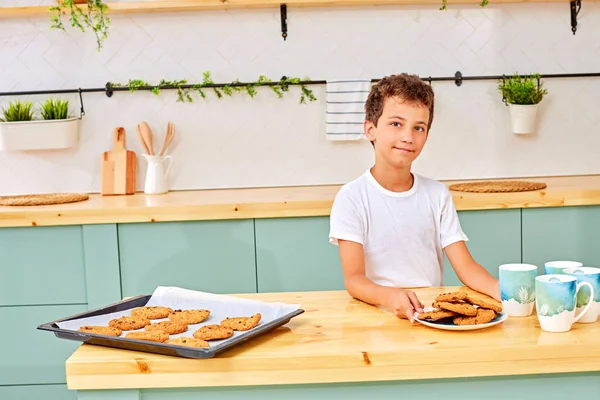 Es un momento agradable. alegre agradable feliz chico sentado a la mesa y tomar el té mientras descansa en casa — Foto de Stock