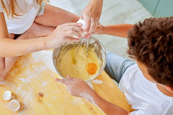 Vista recortada del niño añadiendo huevos a la harina en un tazón de vidrio —  Fotos de Stock