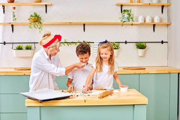Madre e hijos preparando pastelería en la cocina — Foto de Stock