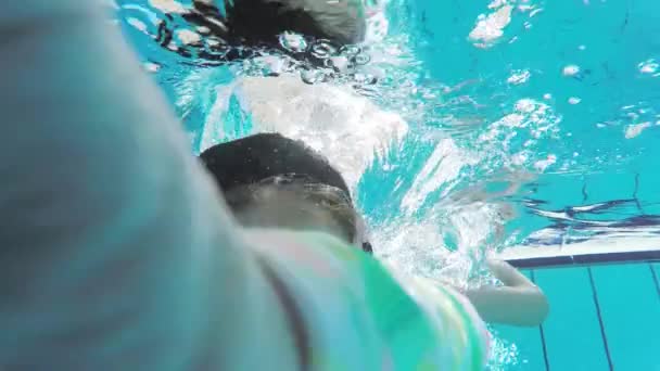 Dziewczynka nosi maskę z rurką, pływać pod wodą w basenie. Zwolnionym tempie. — Wideo stockowe