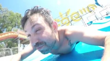 Kaydıraktaki su parkında. Su kaydırağında mutlu adam.