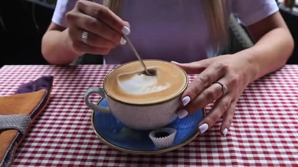 Mulher mexe açúcar no chá com uma colher em uma caneca branca — Vídeo de Stock