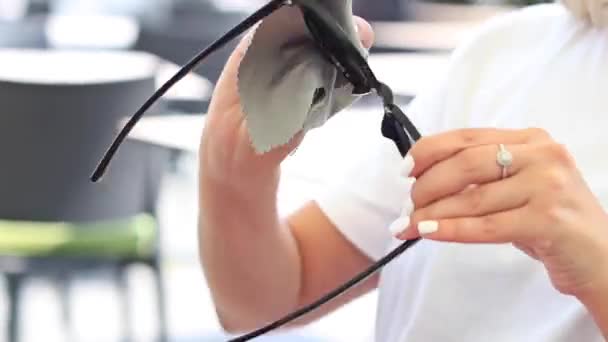 Mujer con limpieza de servilleta gris Gafas de sol — Vídeos de Stock