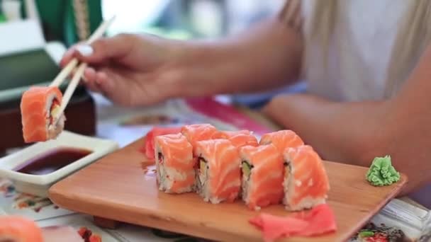 Yemek çubukları dunks ile kadın el Closeup çekim şık soya sosu içine belirlenen suşi koydu — Stok video