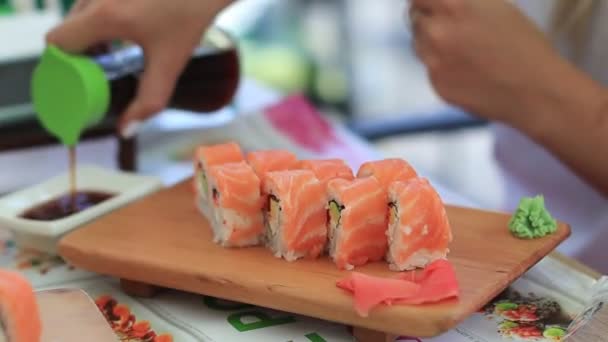 Η γυναίκα τρώει σούσι. Μια γυναίκα ρίχνει σάλτσα σόγιας — Αρχείο Βίντεο