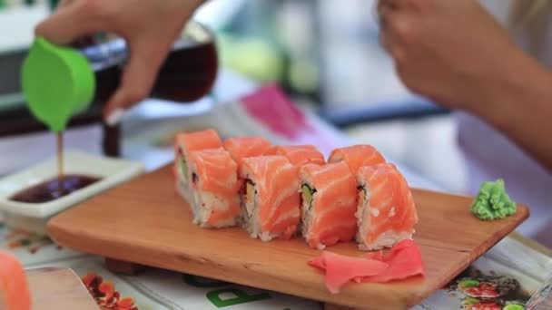 Mujer blanca degustando delicioso sushi con salmón y queso crema preparado por el chef de sushi — Vídeos de Stock