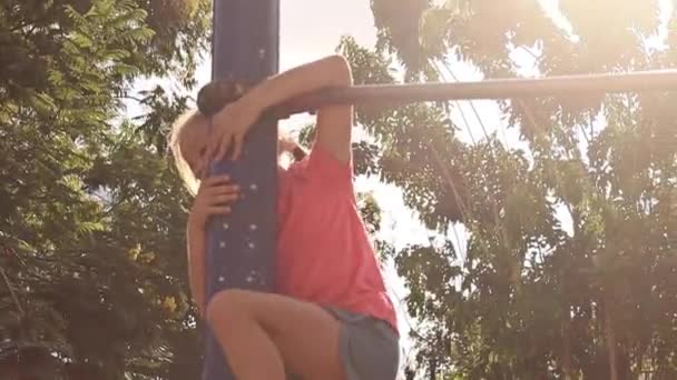 Little girl on horizontal bar in park outdoors — Stock Video