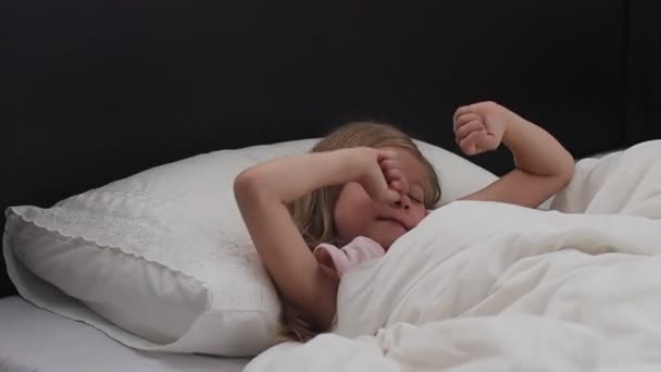 Niña despierta del sueño.Una niña linda disfruta de la mañana soleada. Buenos días en casa. — Vídeo de stock