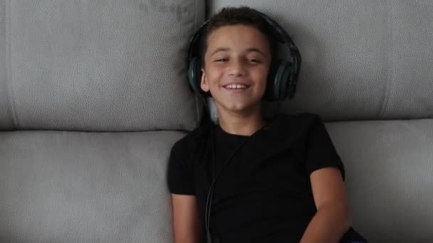 Boldog fiú nevetve otthon fejhallgató — Stock videók