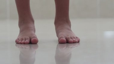Çocuk ayakları türü. Çocuklar yalınayak yerdeler. Odanın aydınlık zemini. Yaz günü