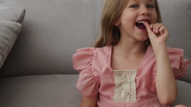 Koncepce zubaře, modrooká blondýnka se směje a ukazuje první vratatý zub — Stock video