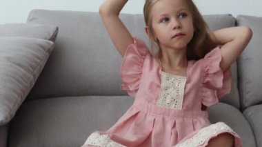 küçük kız odasında yumuşak ışık bir kanepede oturan onu beyaz saç tarama