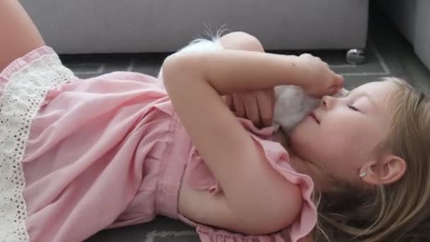 Casa criança animal menina brinca com cobaia animal de estimação deitado no chão . — Vídeo de Stock