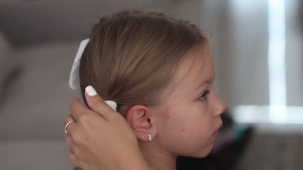 A mãe faz penteado para a filha. Tiro nas costas — Vídeo de Stock