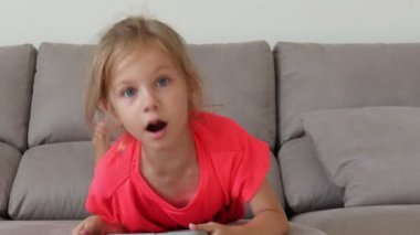 Gri bir kanepeüzerinde yatan dokunmatik ekran kız