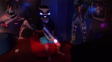 Boy in VR glasses of virtual reality playing game. Virtual augmented reality helmet