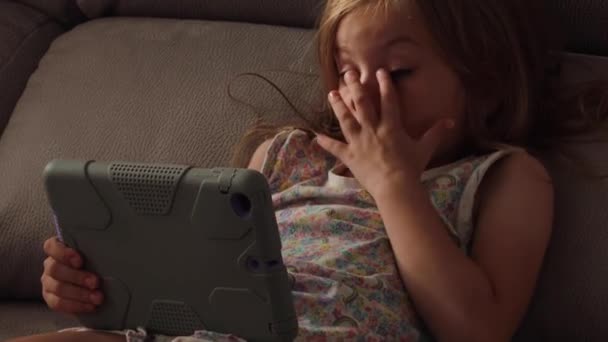 Hermosa niña con gadget en la cama por la noche. Hora de dormir. primer plano — Vídeo de stock