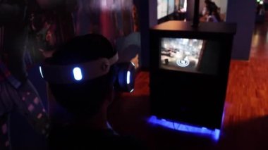 Portrait of excited young man wearing modern goggles and interacting with virtual reality