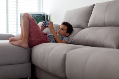 çocuk telefonda kanepede yatan