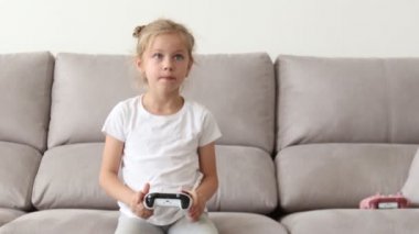 Video Oyun Konsolunda Oynayan Kız, Joystick Kumandasını Kullanıyor. Mutlu sarışın kız Video oyunları oynamak