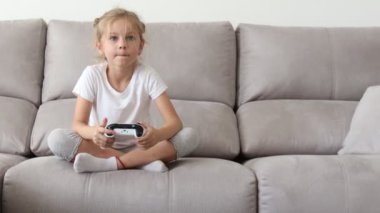 Video Oyun Konsolunda Oynayan Kız, Joystick Kumandasını Kullanıyor. Mutlu sarışın kız Video oyunları oynamak.